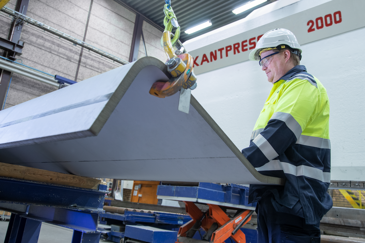 Degerfors Coil Service Center bending 2300 ton with worker examining the results